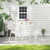 A white aluminum bistro set with a rose pattern sits on a patio next to a white house with a window. Náhľad obrázku produktu