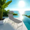 A gray lounge chair with a canopy is set up on a white patio next to an infinity pool overlooking the ocean. Náhled obrázku produktu