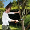 A man is pruning a tree with a handsaw in a garden. Náhled obrázku produktu