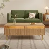 A living room scene with a green sofa and a wooden coffee table. Produktbild-Vorschau