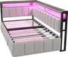 A corner view of a light gray upholstered bed frame with pink LED lighting and a slatted mattress support. Podgląd zdjęcia produktu
