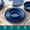 A table setting with blue stoneware plates, bowls, and cutlery, along with a glass of water. Voir les images du produit