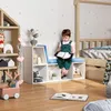 A child is sitting on a storage bench in a nursery or playroom, reading a book. Produktbild-Vorschau