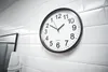 A clock is mounted on a white tiled wall. Anteprima dell’immagine prodotto