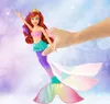 Ariel mermaid doll being held by a hand, with a colorful tail and accessories. Anteprima dell’immagine prodotto