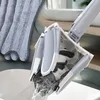 A close-up of a mop head being rinsed in a bucket, with a microfiber cloth visible in the background. Produktbild-Vorschau