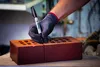 A gloved hand holding a Sharpie marker is marking a line on a brick. Anteprima dell’immagine prodotto