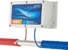 A white electronic water descaler unit mounted on a wall, with red and blue coiled tubes attached to a metal pipe. Produktbild-Vorschau