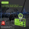 A person lying on the ground with a disaster radio and an emergency light. Produktbild-Vorschau