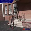 A black multi-purpose ladder is set up on outdoor stairs next to a brick building. Produktbild-Vorschau