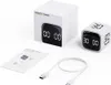 A white gravity timer cube, its packaging, and a USB charging cable are displayed on a white background. Produktbild-Vorschau