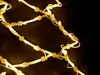 A close-up of a string of white LED lights with yellow illumination against a dark background. Produktbild-Vorschau