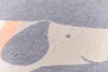 A close-up view of a blanket with a cartoon dog pattern. Produktbild-Vorschau