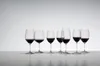 A set of seven wine glasses filled with red wine, arranged in a row on a white surface against a light gray background. Podgląd zdjęcia produktu