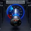 A car charger with a digital display showing battery voltage, set against a dark, abstract background. Náhľad obrázku produktu