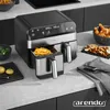 A modern kitchen countertop scene featuring a dual-chamber air fryer with fries and chicken. Produktbild-Vorschau