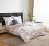 A bedroom scene with a bed made up with floral patterned bedding. Podgląd zdjęcia produktu