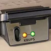 A close-up shot of the control panel of a Krups waffle maker, showing indicator lights and a power switch. Anteprima dell’immagine prodotto