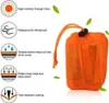 An orange emergency bivvy bag with drawstring closure, surrounded by icons and text describing its features. Podgląd zdjęcia produktu