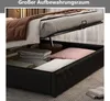 A bed with its storage compartment open, showing stored items like pillows and folded linens. Produktbild-Vorschau