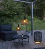An outdoor patio setting with furniture, a coffee table, and solar-powered hanging lamps. Produktbild-Vorschau
