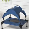 A blue elevated dog bed with a canopy, set against a white wooden wall. Anteprima dell’immagine prodotto