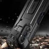 A rugged phone case is shown in a dramatic setting with debris flying around it. Náhľad obrázku produktu