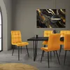 A dining room scene with four yellow velvet chairs around a black dining table, with a large abstract artwork on the wall. Náhled obrázku produktu