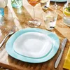 A table setting with plates, cutlery, and drinks on a wooden table. Anteprima dell’immagine prodotto