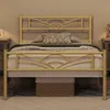 A gold metal bed frame with a cloud pattern headboard is shown in a bedroom setting. Produktbild-Vorschau
