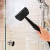 A hand is using a steam cleaner to clean a glass shower door. Produktbild-Vorschau