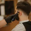 A barber is trimming a man's hair with an electric trimmer. Náhled obrázku produktu