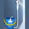 A portable shower pump is shown in a blue bucket filled with water, with the shower head spraying water. Produktbild-Vorschau