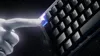 A hand is pressing a button on a keyboard with glowing keys. Produktbild-Vorschau