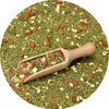 A close-up view of loose-leaf mate tea with goji berries and other dried ingredients, with a wooden scoop resting on top. Voir les images du produit
