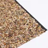 A close-up view of a textured material composed of small, multi-colored pebbles embedded in a dark backing. Produktbild-Vorschau