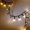 A string of fairy lights is draped across a light-colored surface, casting soft shadows. Produktbild-Vorschau