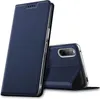 A dark blue flip case for a smartphone is shown against a white background. The case is partially open, revealing the back of a smartphone with a triple camera setup. Produktbild-Vorschau