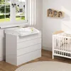 A nursery room with a changing table, crib, and shelves. Produktbild-Vorschau