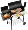 A black charcoal grill with two chambers, one containing a whole roasted chicken and the other containing various meats and skewers. It has a wooden side table and a bottom shelf, and is set against a white background. Náhled obrázku produktu