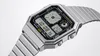 A close-up studio shot of a silver digital watch with a black face. Voir les images du produit