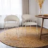 Two chairs are placed on a round rug in a dining area, with a table and dried flowers in the background. Podgląd zdjęcia produktu