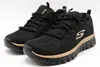 A pair of black Skechers sneakers with rose gold accents, displayed on a white background. Produktbild-Vorschau