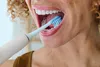 A close-up shot of a person brushing their teeth with an electric toothbrush. Anteprima dell’immagine prodotto