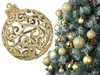 A gold Christmas ornament is shown next to a decorated Christmas tree. Anteprima dell’immagine prodotto
