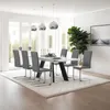 A modern dining room with a white table and gray chairs, set up for a meal. Voir les images du produit