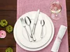 A table setting with cutlery, plates, a wine glass, and a napkin. Voir les images du produit