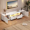 A modern white TV stand with LED lighting is shown against a light gray and white paneled wall, with a large television mounted above it. Produktbild-Vorschau