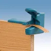 A close-up shot of a teal edge banding trimmer tool on a wooden surface. Anteprima dell’immagine prodotto