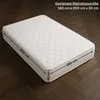 A white mattress with diamond quilting is shown on a dark wooden floor. Produktbild-Vorschau